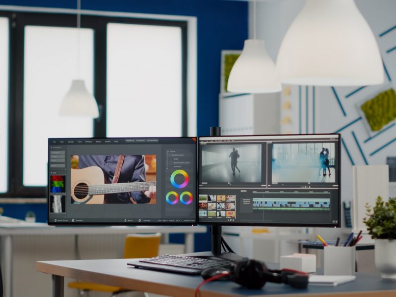 Empty modern creative agency office with dual monitors setup Empty modern creative agency office with dual monitors setup with processing video film montage. Video editing start up studio company with no people in it and post production software on pc displays